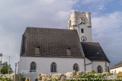 Die Kirche in Arbing mit dem Kirchturm aus der Zeit um 1510, dessen Aufsatz mit den Ecktürmchen, Erkern und Rundbogenzinnen datiert um 1600.