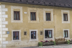 Zwischen den modernen Fenstern befinden sich zwei kleine fast quadratische (Fenster-)Öffnungen mit schmiedeeisernen Gitter. Im oberen Stock befindet sich schwarz gerahmt auf weißem Grund die Jahreszahl 1588.