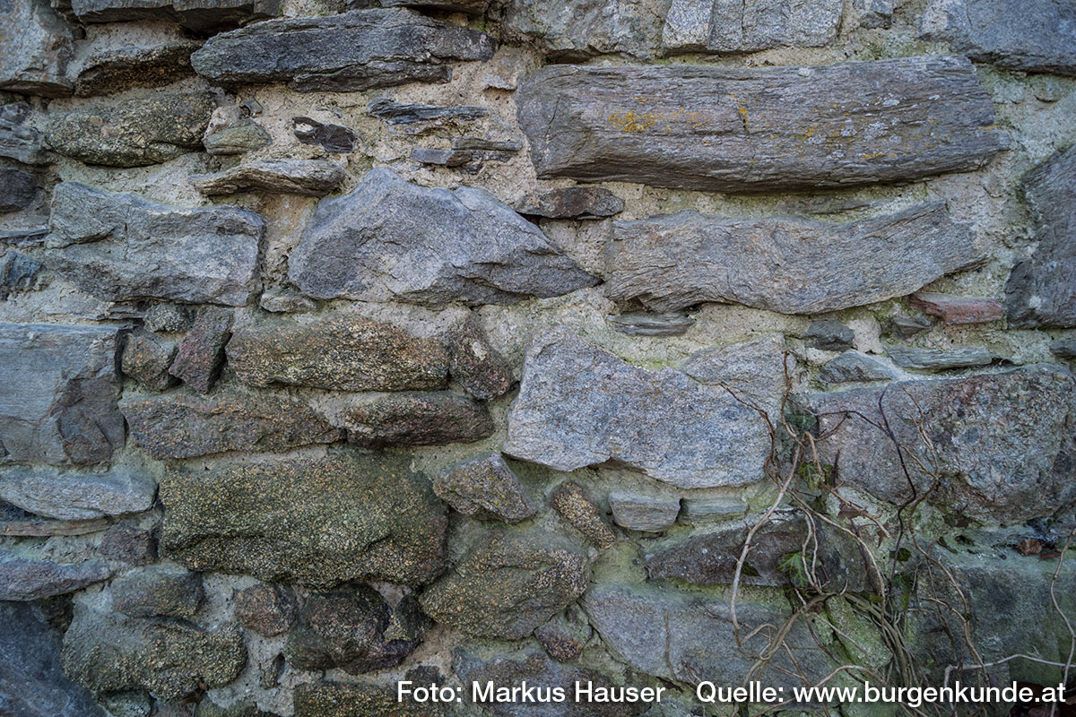 Am Fuße des Turmes sind zwei unterschiedliche Gesteinsarten im Mauerwerk erkennbar.