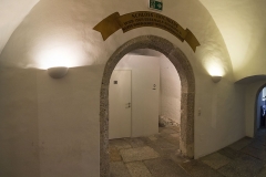 Im ebenerdigen Mittelgang führt ein großes rundes Tor zum einstigen Verlies und dem darunter liegenden "tiefen Keller". Früher war im Verlies das "Heurigen Stüberl", heute sind die Toilettenanlagen untergebracht.