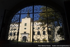 Von der gewölbten Durchfahrt genießt man durch ein schmiedeeisernes Tor bereits den Anblick von Schloss Kremsegg.