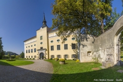 Der Tortrakt ist mit dem Schloss durch eine hohe Mauer verbunden, die eine Schießscharte und ein schmiedeeisernes Tor aufweist.