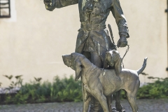 In der Mitte vorm Schloss befindet sich ein Brunnen samt jagdhornblasenden Jägerfigur mit Hunden.