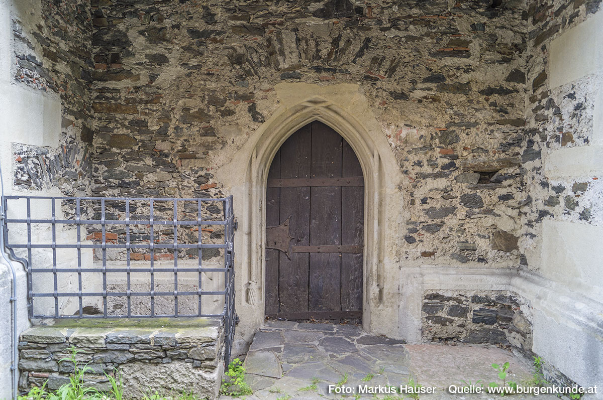 Auch an der Nordseite gibt es einen Zugang durch dieses spitzbogige, gotische, gestäbte Portal. Links ein Abgang.
