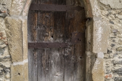 Der Zugang zur Kapelle mit Beinhaus und Karner erfolgt durch diese gotische kleine Tür, dessen spitzbogige Umrandung noch Reste von weißer und roter Bemalung zeigt.