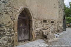 Neben der gotischen Eingangstüre in die Kapelle befinden sich noch zwei schmale, schlitzartige Öffnungen.