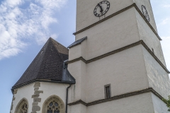 Der Aufsatz des Kirchturms mit Ecktürmchen, Erkern und Rundbogenzinnen datiert um 1600. Der Turm selbst und der Chor stammen aus der Zeit um 1510.